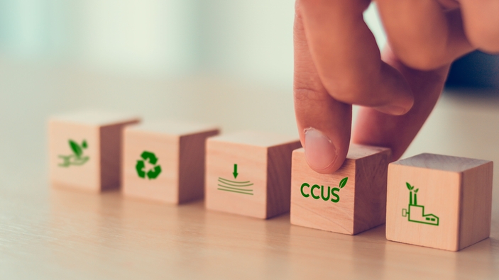 Beş ahşap blok ile sembolize edilen Karbon Yakalama, Kullanma ve Depolama (CCUS) konsepti.